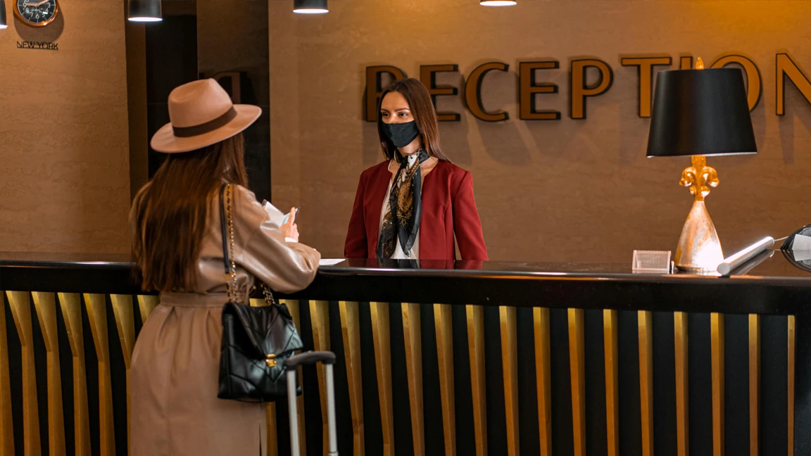 Gost se prijavljuje na recepciji hotela uz pomoć zaposlenice
